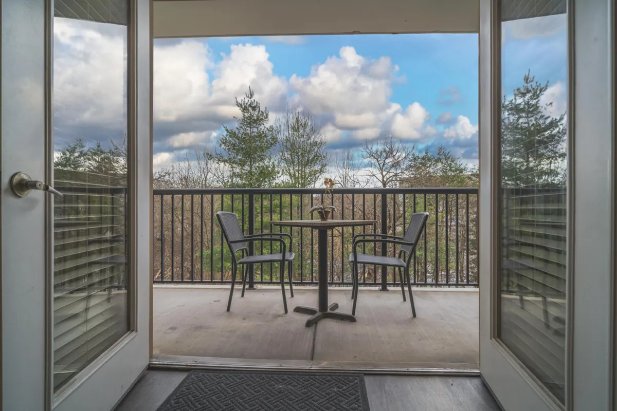 A peaceful outdoor setting with a table and chairs facing trees and an open sky, suggesting a perfect spot for morning coffee, reading, or simply taking in the scenery. The scene is quiet and intimate, capturing the serenity of the resort’s natural surroundings.